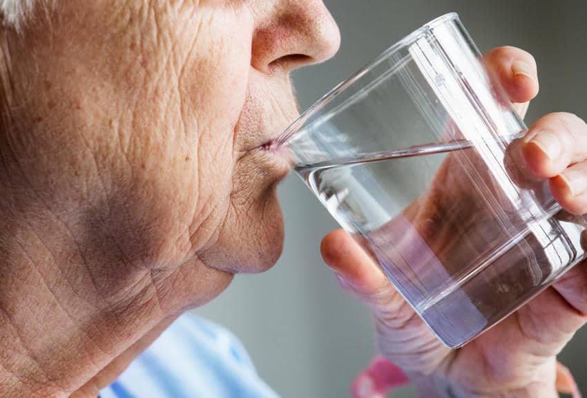Side View Of Elderly Woman Drinking Water